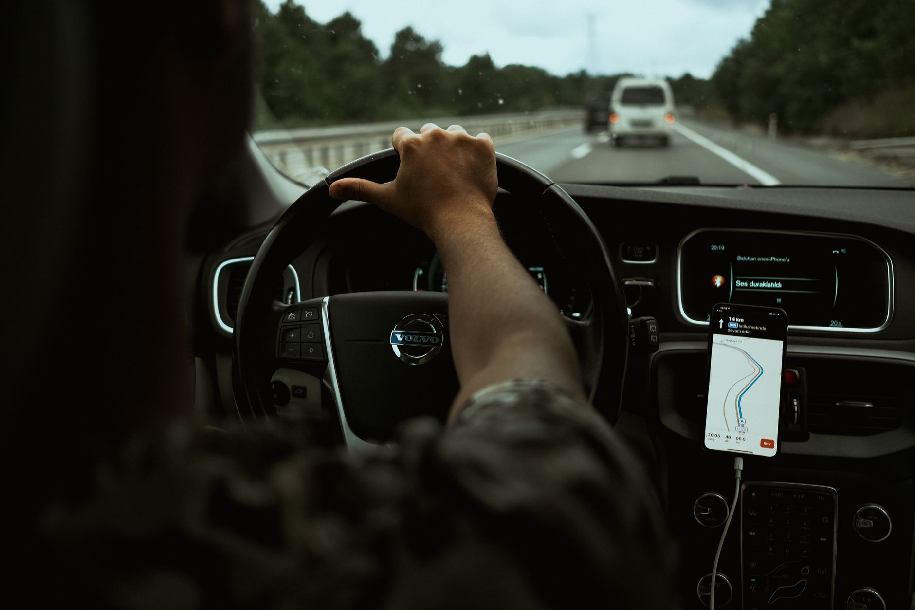 Phone mounted on a car dashboard displaying turn-by-turn navigation