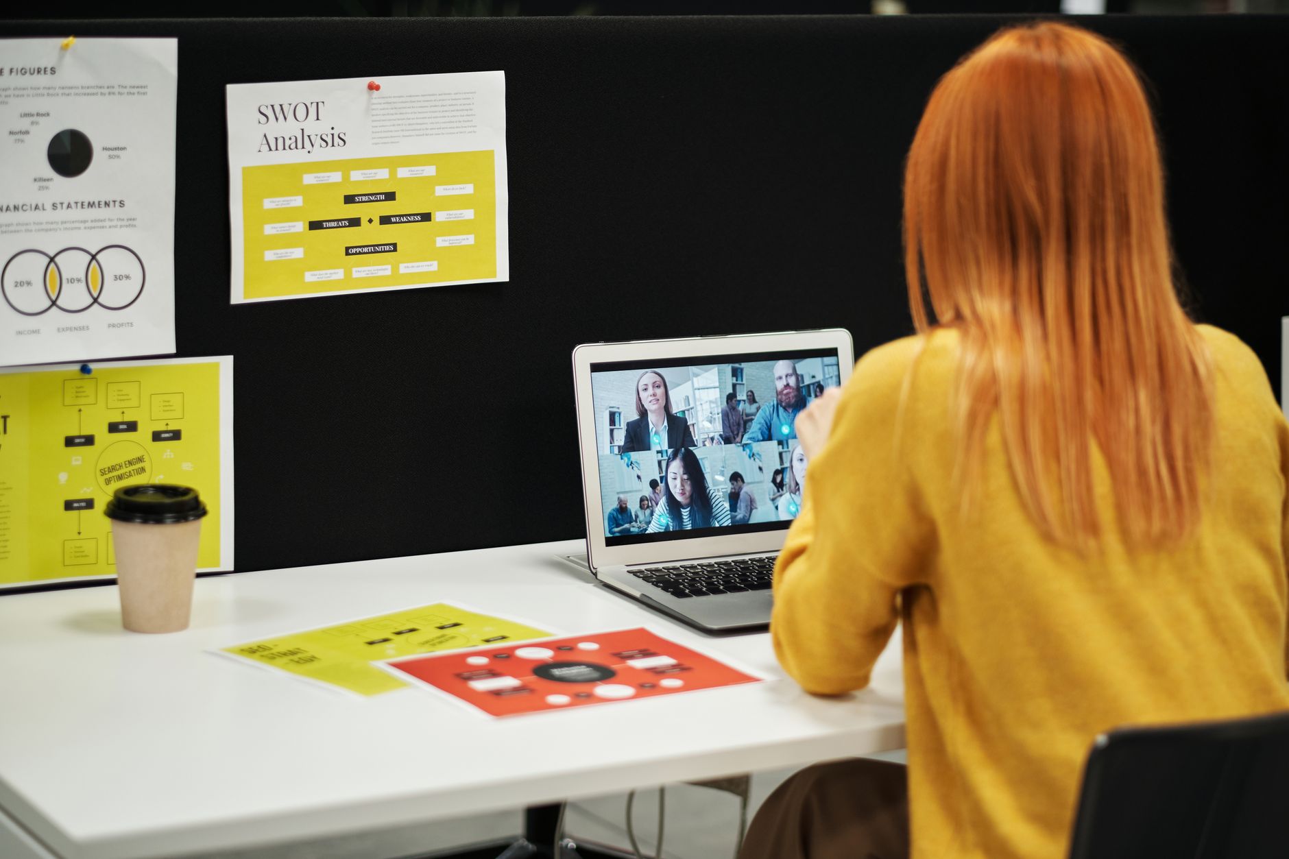 Remote team members on a video conferencing software call using laptops
