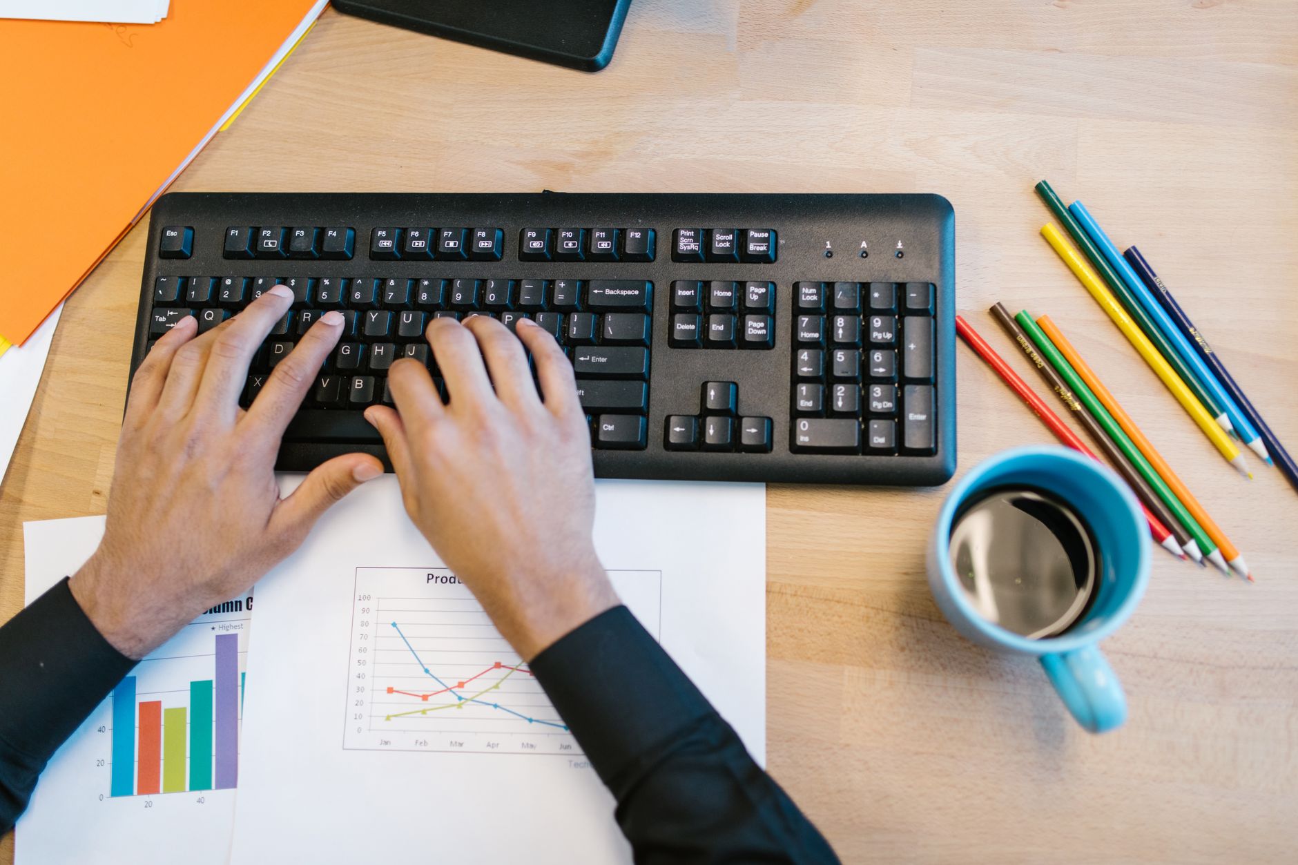 Hands typing on a keyboard next to notes, representing a comparison of AI Overview workarounds